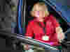 A Royal Voluntary Service volunteer in the driver's side of a car helping suport a hospital patient 