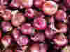 A close up of a pile of red onions 