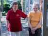 A volunteer helping an older woman in the community 