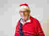 Royal Voluntary Service lunch club participant wearing a Christmas jumper, Santa hat and tinsel